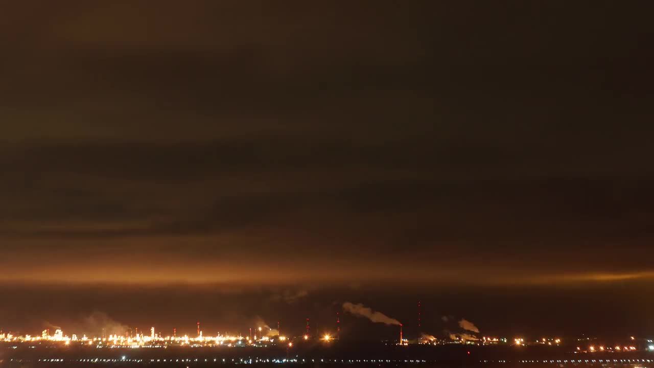 夜晚的炼油厂上方飘动的云层视频素材