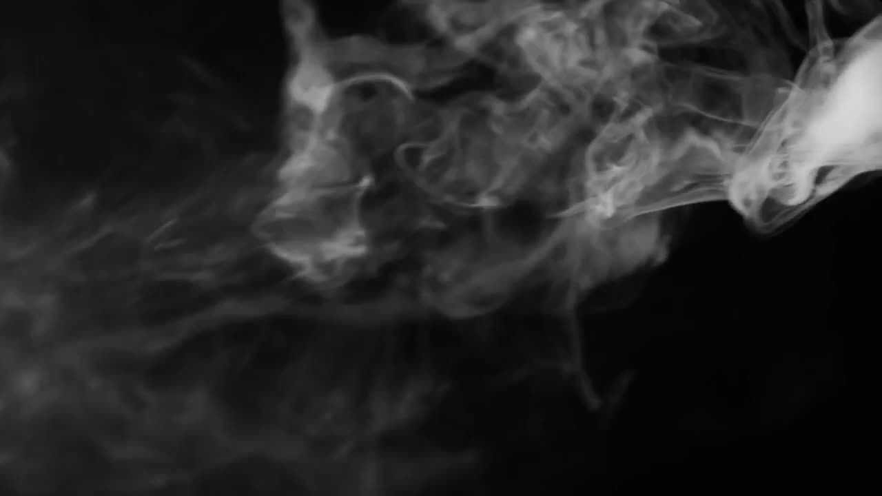 黑色背景上流动的薄薄的白色烟雾实拍视频素材