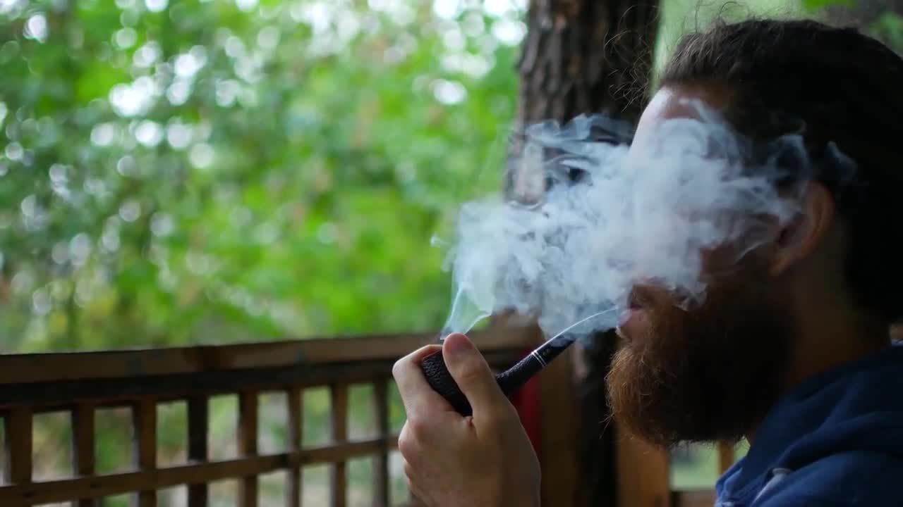 户外吸着烟斗的男人实拍视频素材