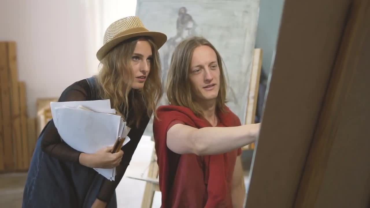 女艺人和男同事讨论绘画实拍视频素材