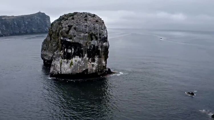 多云的天空下水中的大岩层航拍视频