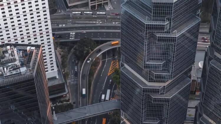 在城市空中的摩天大楼附近驾驶的车实拍视频素材